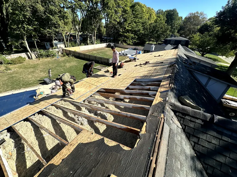Roof torn off down to the rafters with crew replacing decking